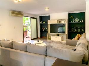 a living room with a large couch and a television at Casa Avellaneda I 12 pax - A 6 cuadras Arístides in Mendoza