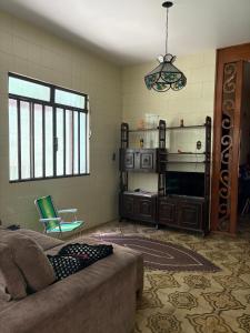 a living room with a couch and a television at NóIS DE CASA HOSTEL & SUÍTES in Belo Horizonte
