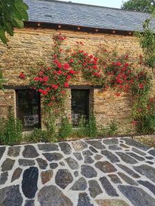 a building with red flowers on the side of it at Le Temps du Coeur - TYNID in Saint-Ganton +5 photos