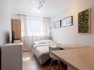 a bedroom with a bed and a desk and a table at Apartament Antoninek in Poznań