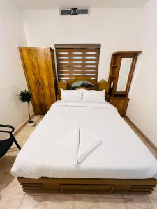 a bedroom with a large bed with white sheets at Elowen Villa in Mananthavady
