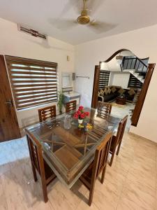 a dining room with a glass table and chairs at Elowen Villa in Mananthavady