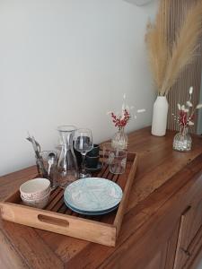 a wooden tray with plates and glasses on a wooden table at Studio en Luberon in La Bastidonne