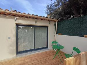 a patio with a table and chairs on a deck at Studio en Luberon in La Bastidonne