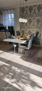 a dining room with a table and chairs and a kitchen at Ferienhaus-Windflüchter Hirtenweg 3B in Zingst