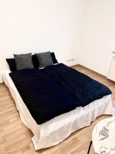 a bed with a blue blanket on it in a room at Ferienwohnung Sophie in Weil am Rhein