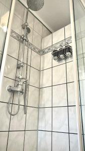 a bathroom with a shower with white tile at Ferienwohnung Sophie in Weil am Rhein