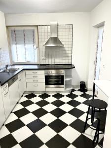 a kitchen with a black and white checkered floor at Ferienwohnung Sophie in Weil am Rhein +13 photos