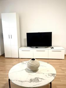 a living room with a table and a tv at Ferienwohnung Sophie in Weil am Rhein