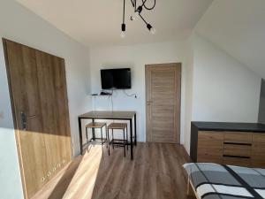 a bedroom with a bed and a table and chairs at Noclegi u Adama in Probark