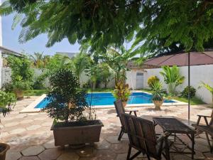 a patio with a table and chairs and a pool at Villa Aria in Mbour