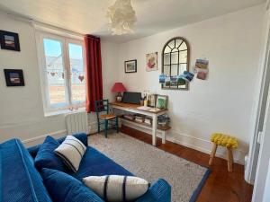 a living room with a blue couch and a desk at Le toit de Veules - Proche Mer - Veules les Roses in Veules-les-Roses