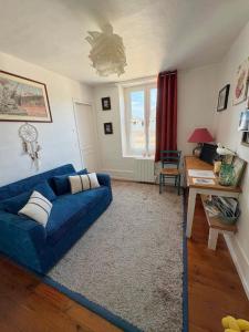 a living room with a blue couch and a desk at Le toit de Veules - Proche Mer - Veules les Roses in Veules-les-Roses