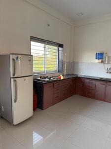 an empty kitchen with a refrigerator and a stove at Nahta's Farm in Indore