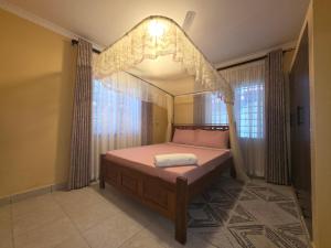 a bedroom with a canopy bed with a window at The Hidden Paradise in Mombasa +130 photos