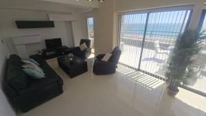 a living room with couches and a view of the ocean at La PERLA DEL MORRO in Porlamar