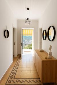 a hallway with a door leading to a room with a window at Perioptron Guesthouse Ithaca in Vathi