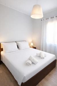 a bedroom with a large white bed with white pillows at Perioptron Guesthouse Ithaca in Vathi