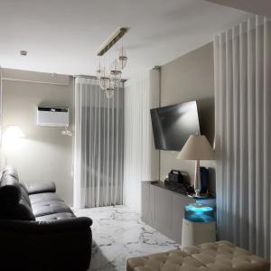 a living room with a couch and a television at MeCasa in Mactan Island