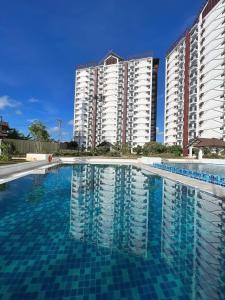 a swimming pool in front of two tall buildings at MeCasa in Mactan Island