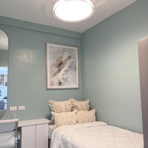 a bedroom with a bed and a blue wall at MeCasa in Mactan Island +43 photos