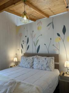 a bedroom with a bed with flowers on the wall at Hostal Chucaita Puerto Cisnes in Puerto Cisnes