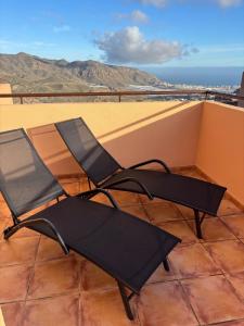 two chairs sitting on top of a balcony at Taína La Encina in Vícar