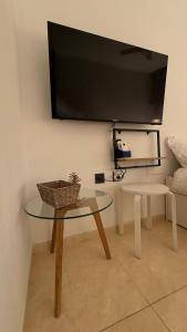 a living room with a table and a flat screen tv at Taína La Encina in Vícar +8 photos