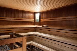 an empty wooden sauna with a bench in it at Landhotel Maiergschwendt inkl Chiemgaukarte in Ruhpolding +163 photos