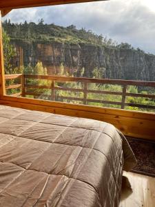 a bedroom with a bed and a view of a mountain at Hotel Rokas de Suesca in Suesca