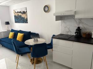 a living room with a blue couch and a table at Luksusowy Apartament Giżycko in Giżycko