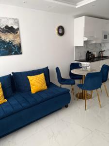a living room with a blue couch and a table at Luksusowy Apartament Giżycko in Giżycko
