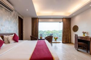 a bedroom with a large bed and a desk at Hotel The Imperio, Near Apollo Hospital, JASOLA in New Delhi