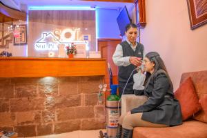 a man standing next to a woman sitting on a couch at Sol Plaza Hotel in Puno