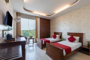 a hotel room with two beds and a desk at Hotel The Imperio, Near Apollo Hospital, JASOLA in New Delhi