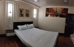 a bedroom with a large white bed with two pillows at Kadamba Bnb Homestay in Kurseong