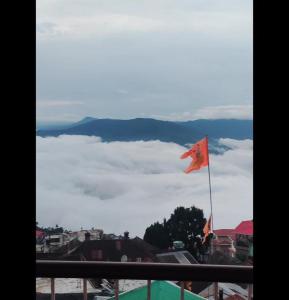 a flag on a balcony with a view of clouds at Kadamba Bnb Homestay in Kurseong +7 photos