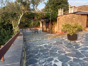 a garden with a stone patio with a yellow hose at Casa Arza in Treacastela