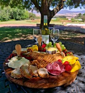 a plate of food on a table with wine glasses at Schalkenbosch Farm Cottages in Tulbagh