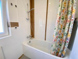 a white bath tub in a bathroom with a shower curtain at Ruhige Gästezimmer in Bonn mit Gemeinschaftsbad & Küche in Bonn +29 photos