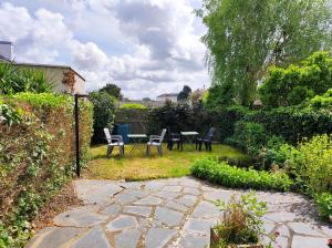 eine Terrasse mit Stühlen und einem Tisch im Garten in der Unterkunft Chambres Spacieuses et Lumineuses - Angers - Votre havre de paix in Angers