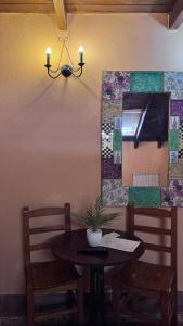 a dining room table with two chairs and a mirror at Casa Cuevas in Caín