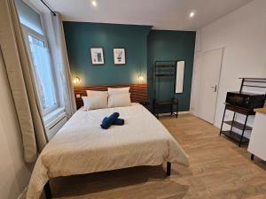 a bedroom with a bed with a blue object on it at LD Atmosphère in Saint-Quentin