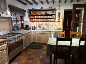 a kitchen with wooden cabinets and a stove top oven at La maison des Grands Vents in Ychippe