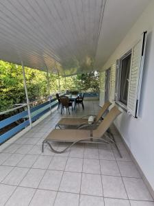 a balcony with chairs and a table on a house at Apartman Magdalena in Cres