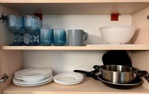a shelf filled with blue glass bowls and plates at Polo Resort studio in Sunny Beach