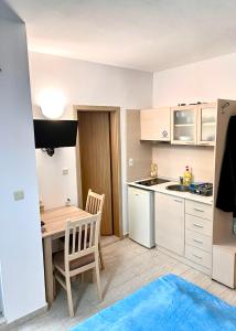 a small kitchen with a wooden table and a dining room at Polo Resort studio in Sunny Beach