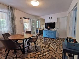 a living room with a table and a tv at Apartman Magdalena in Cres