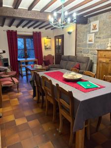 a living room with a table and chairs and a couch at La maison des Grands Vents in Ychippe +16 photos