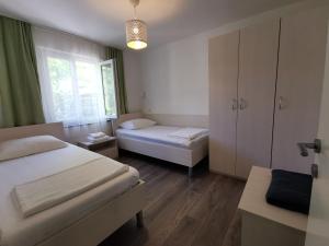 a small bedroom with two beds and a window at Apartman Magdalena in Cres